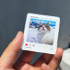 Hand holding a custom acrylic cat photo fridge magnet close up