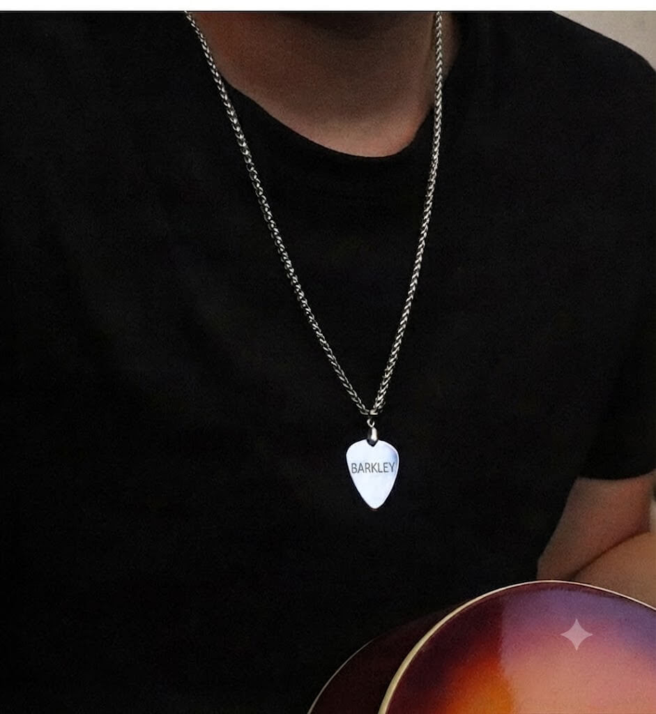Person wearing a custom titanium steel guitar pick necklace engraved with pet name