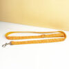 Full length view of orange pumpkin patterned dog leash with gold metal clasp