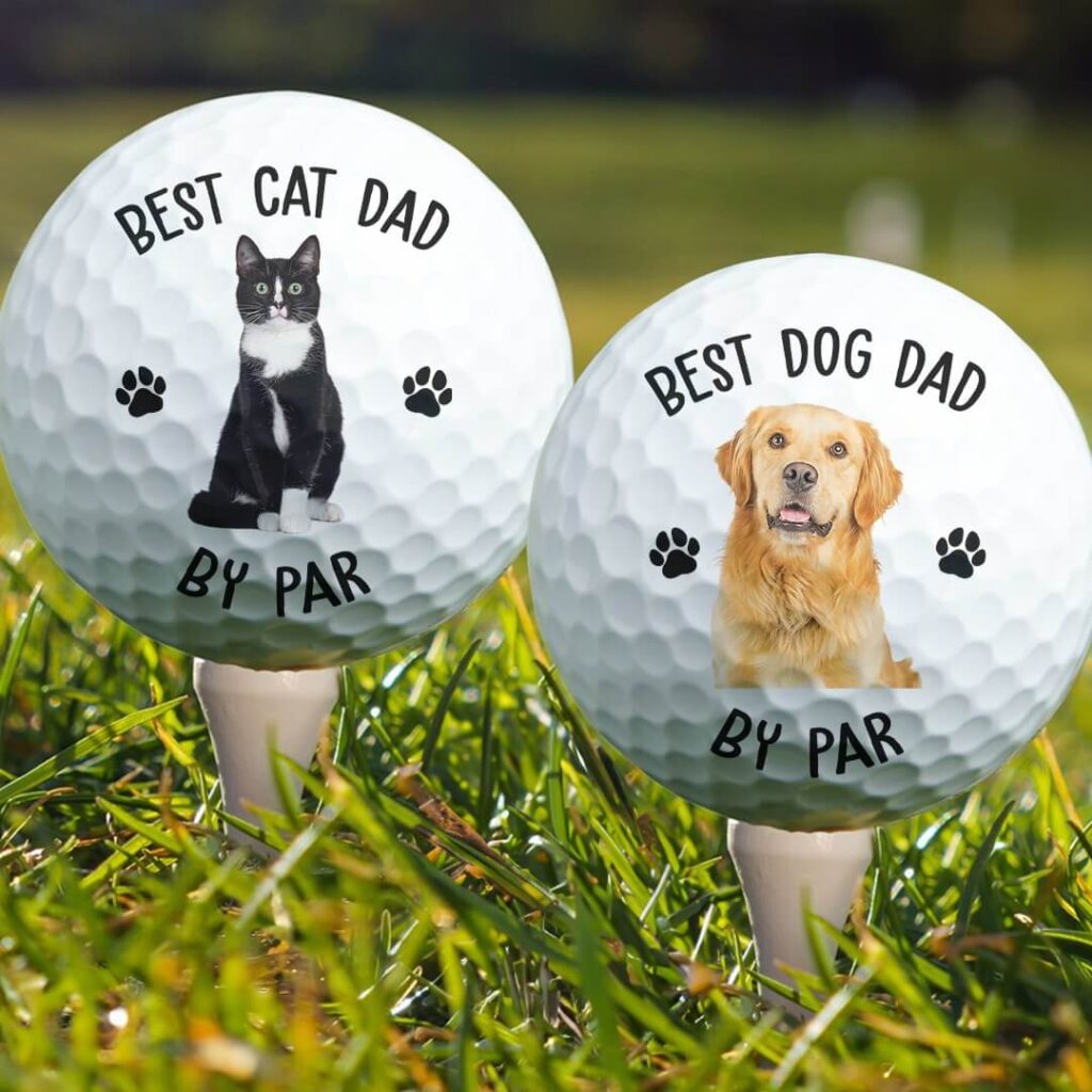 Personalized dog and cat dad golf balls with custom pet portrait prints on green grass